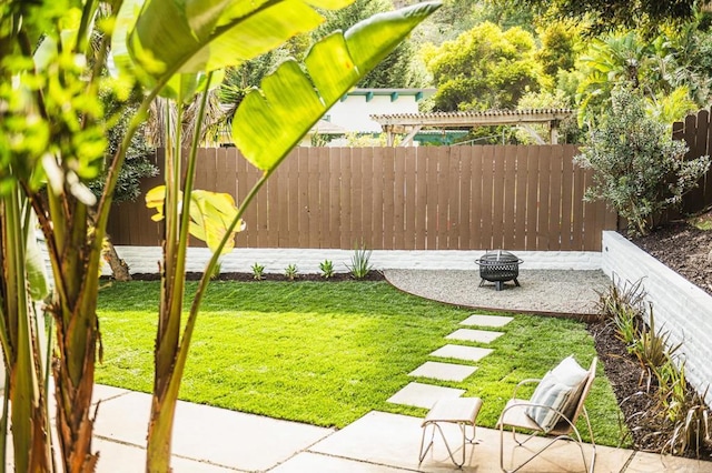 view of yard featuring an outdoor fire pit, a fenced backyard, and a patio