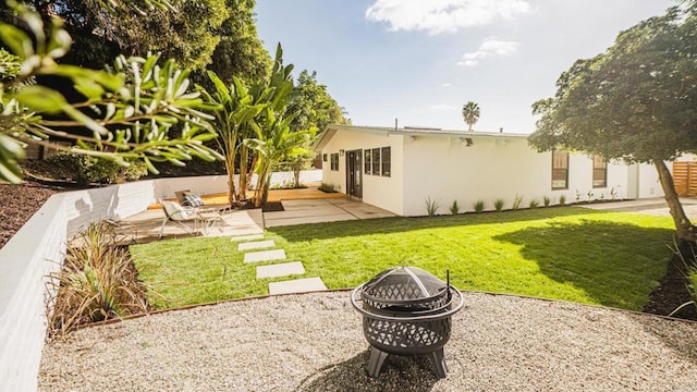 view of yard featuring a patio area, fence, and a fire pit