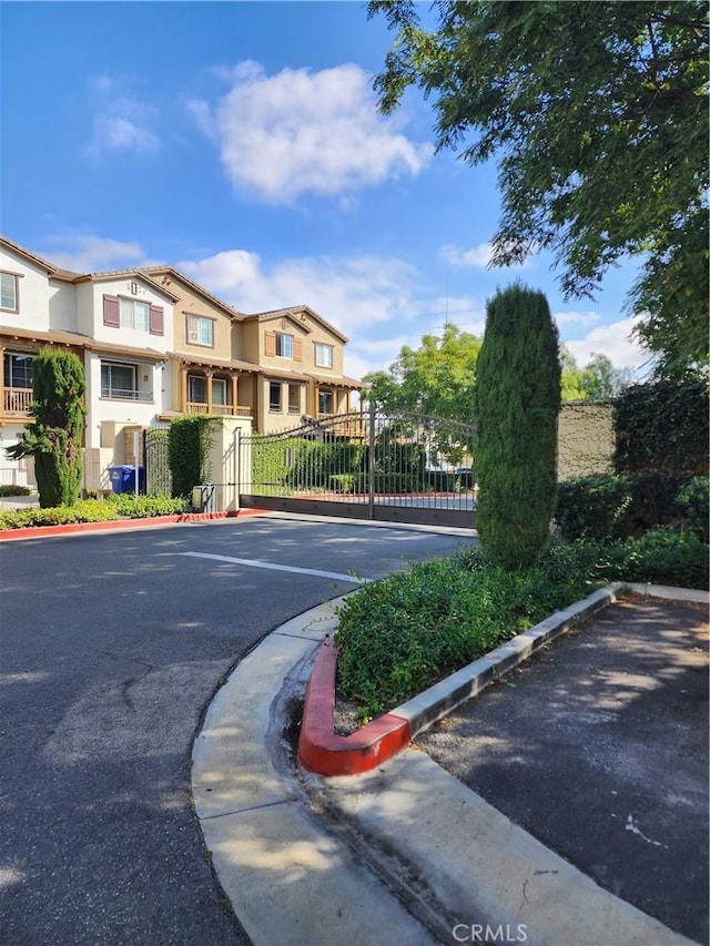 view of street featuring a gate, curbs, and a gated entry