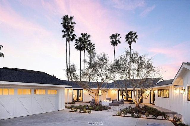 view of front facade featuring an outdoor hangout area, an attached garage, and driveway