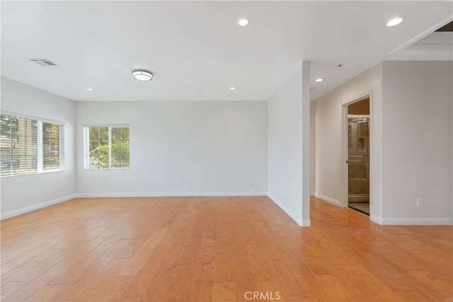 empty room with light wood finished floors, visible vents, and recessed lighting