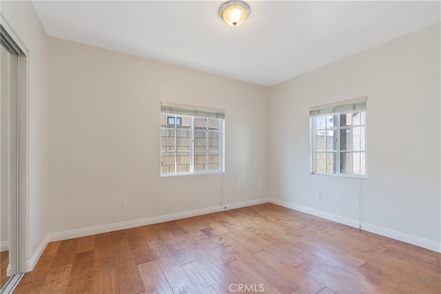 unfurnished room featuring wood finished floors and baseboards