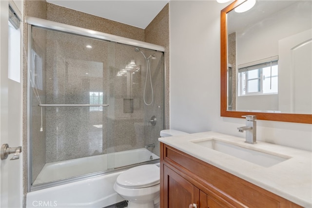 bathroom with toilet, bath / shower combo with glass door, and vanity