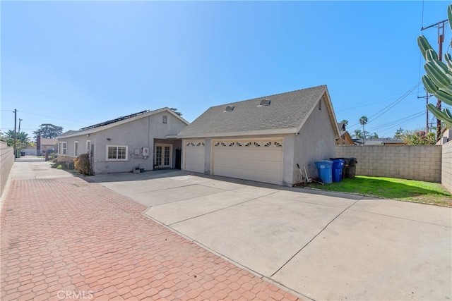 single story home with a shingled roof, fence, concrete driveway, and stucco siding