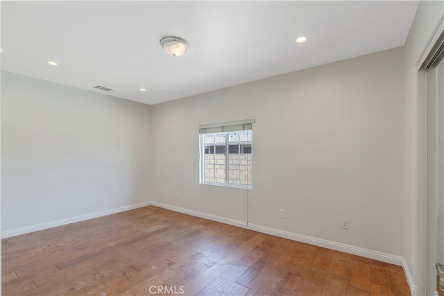 spare room featuring recessed lighting, light wood-type flooring, visible vents, and baseboards