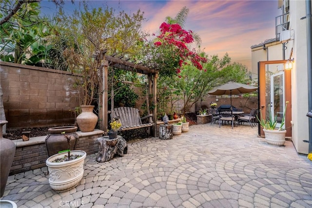 patio terrace at dusk with outdoor dining space and fence