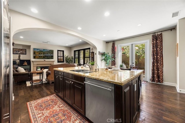 kitchen with a sink, visible vents, dishwasher, and dark wood finished floors