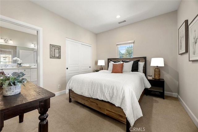 bedroom featuring visible vents, light carpet, baseboards, and ensuite bath