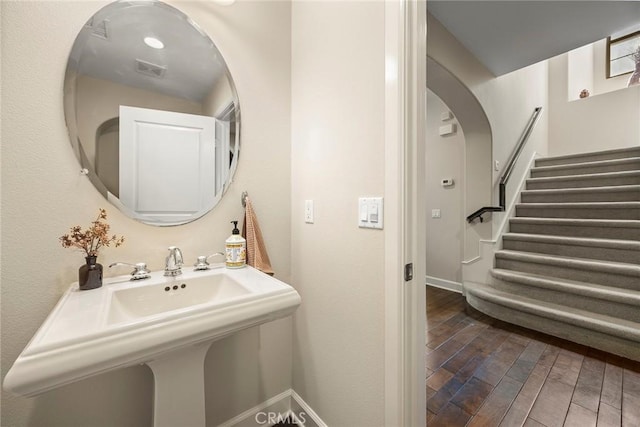 bathroom with wood finished floors, baseboards, and a sink