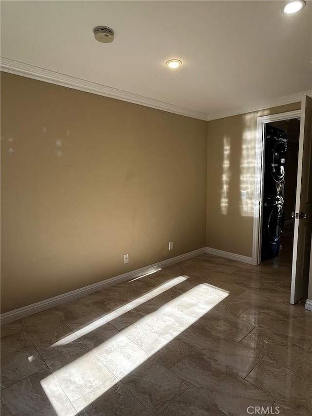 spare room with marble finish floor, baseboards, and ornamental molding