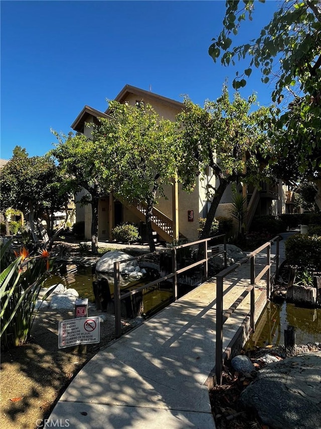 view of property exterior with a boat dock and stucco siding