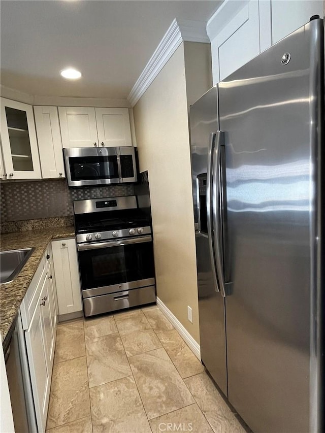 kitchen with white cabinetry, appliances with stainless steel finishes, decorative backsplash, and crown molding