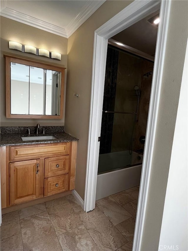 bathroom featuring shower / bath combination with glass door, baseboards, crown molding, and vanity