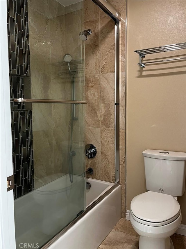 full bath with toilet, shower / bath combination with glass door, and baseboards