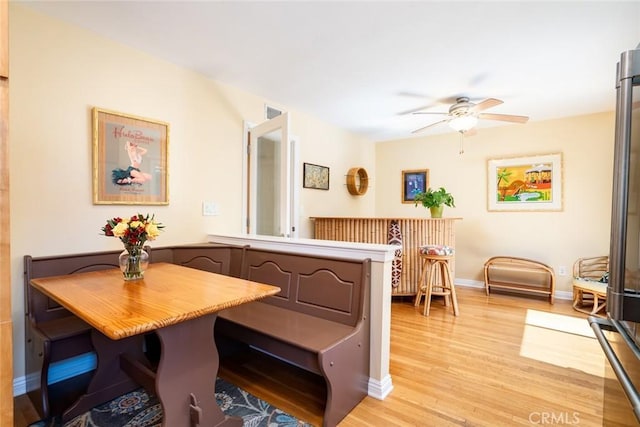 dining space with ceiling fan, breakfast area, light wood-style flooring, and baseboards