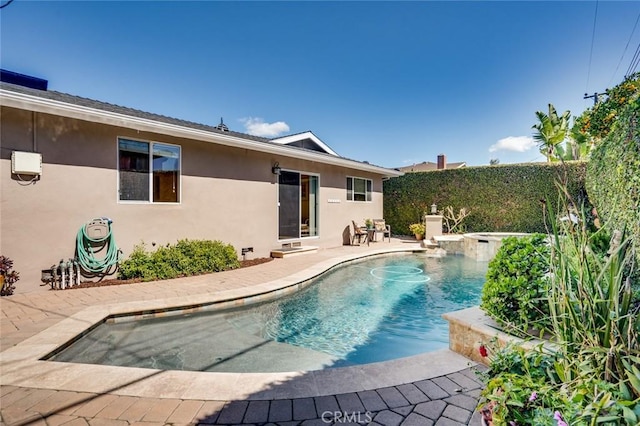 view of pool with a jacuzzi, a fenced in pool, and a patio