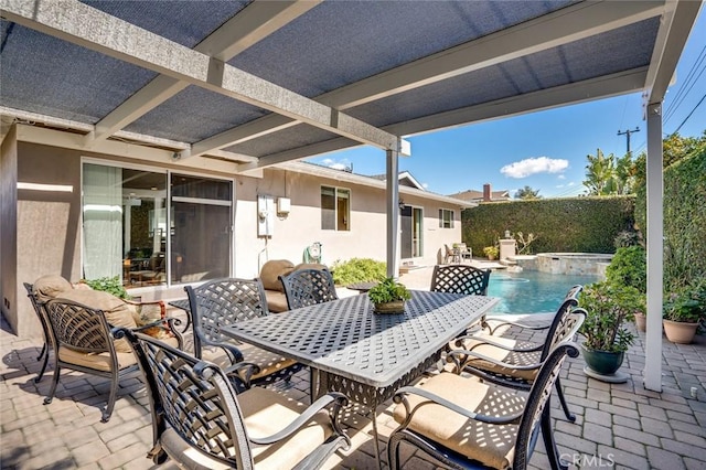 view of patio featuring outdoor dining area, a fenced in pool, and an in ground hot tub