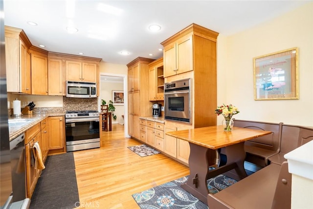 kitchen featuring stainless steel appliances, recessed lighting, backsplash, and light wood-style flooring