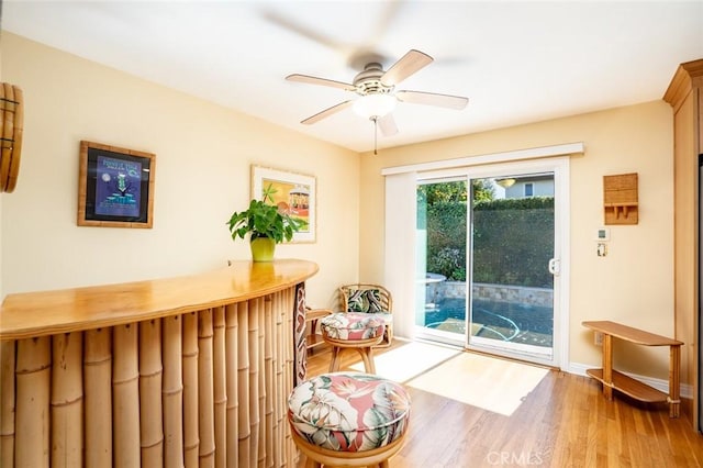 living area with a ceiling fan and wood finished floors