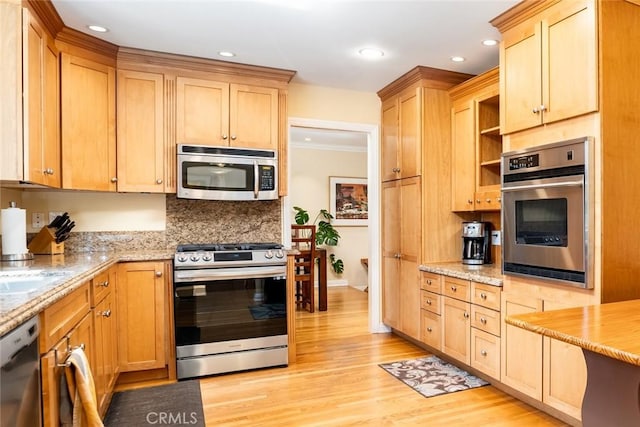 kitchen featuring light brown cabinets, light wood-style floors, appliances with stainless steel finishes, light stone countertops, and tasteful backsplash