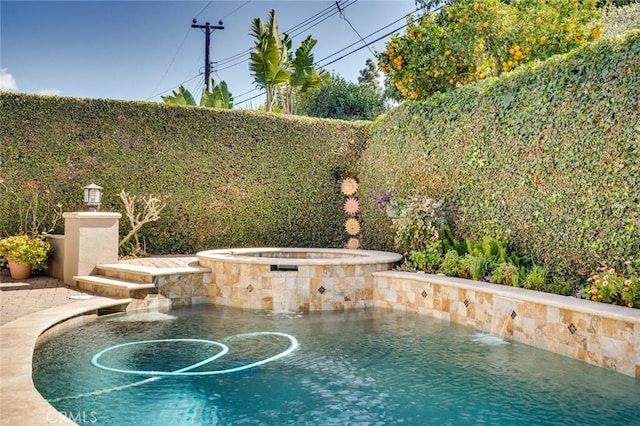 view of pool with a fenced backyard and a pool with connected hot tub