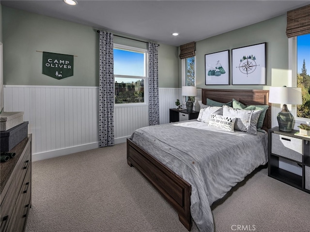 bedroom with recessed lighting, a wainscoted wall, and carpet flooring