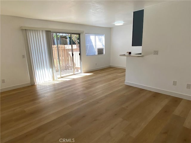 unfurnished living room featuring baseboards and light wood-style flooring