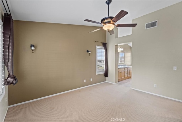 empty room featuring visible vents, ceiling fan, light carpet, and baseboards