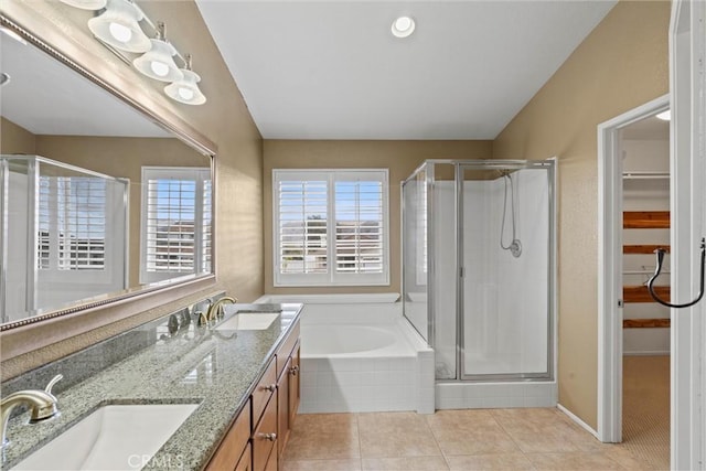 bathroom featuring tile patterned flooring, a sink, a shower stall, and a spacious closet