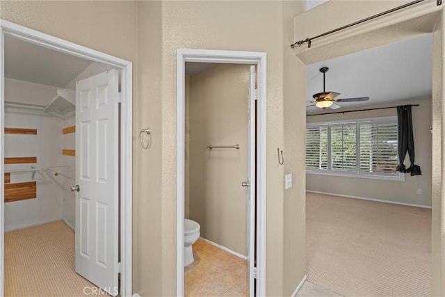 hall featuring carpet floors, tile patterned floors, and baseboards