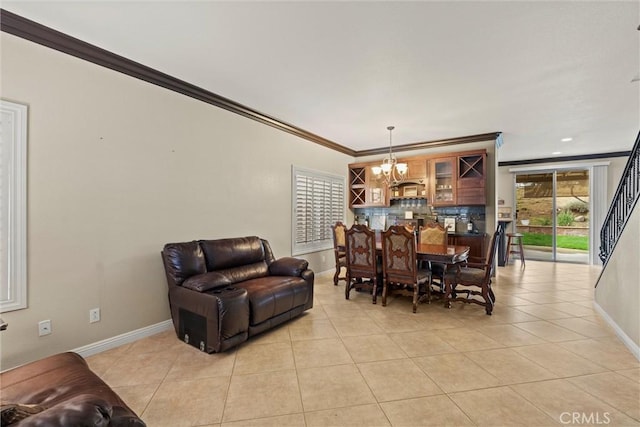 dining space featuring ornamental molding, a notable chandelier, baseboards, and light tile patterned floors