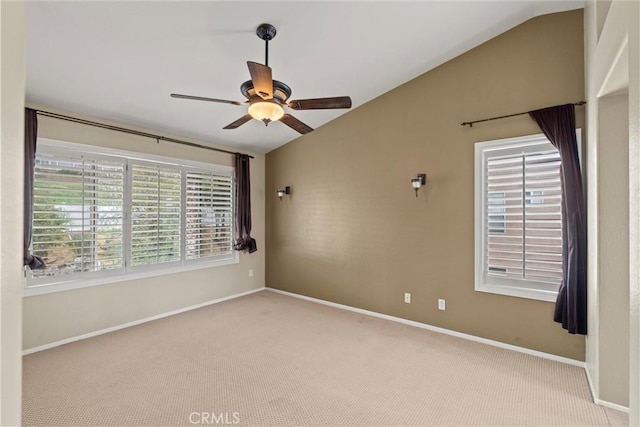 carpeted spare room with a ceiling fan, vaulted ceiling, and baseboards