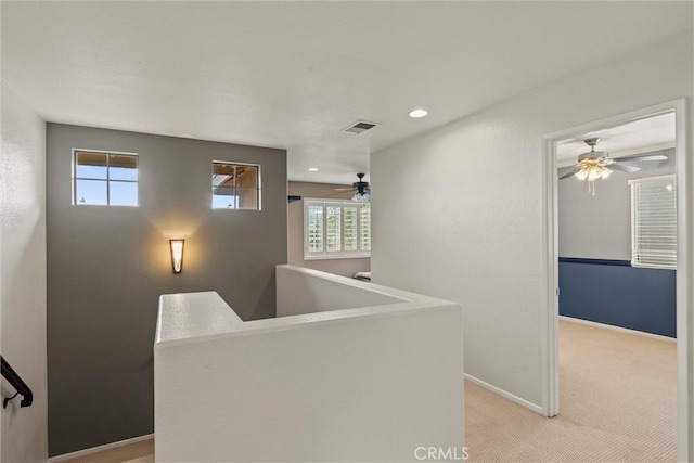 hall featuring recessed lighting, light colored carpet, visible vents, an upstairs landing, and baseboards