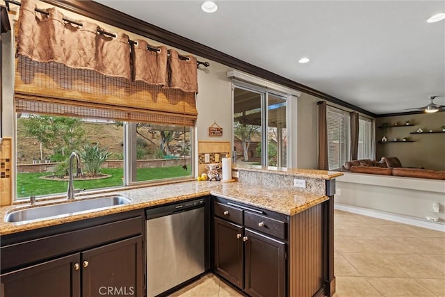 kitchen featuring light tile patterned floors, ornamental molding, light stone countertops, stainless steel dishwasher, and a sink