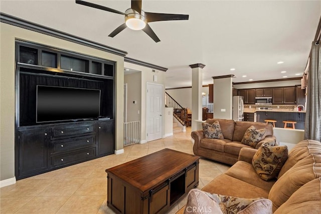 living room featuring light tile patterned flooring, a ceiling fan, baseboards, ornamental molding, and stairway