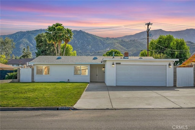 ranch-style house with a mountain view, fence, and a front lawn