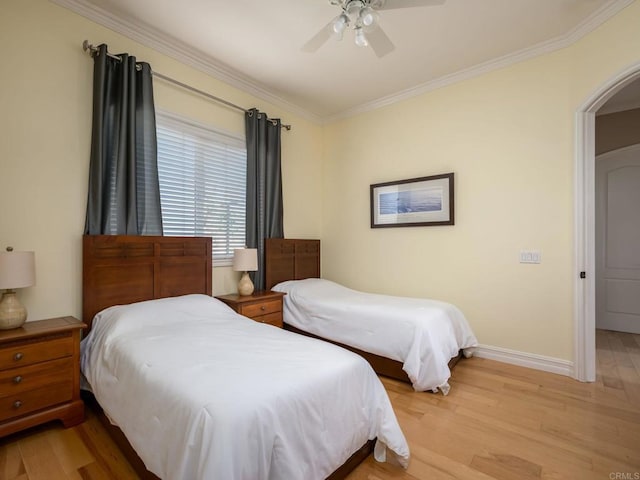 bedroom featuring baseboards, a ceiling fan, light wood-style flooring, and crown molding