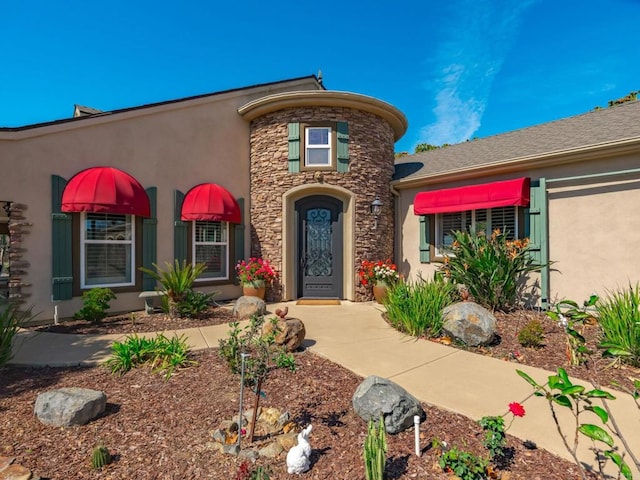 view of front facade with stone siding and stucco siding