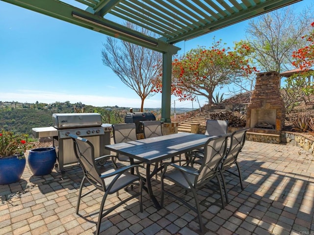 view of patio featuring an outdoor stone fireplace, outdoor dining area, a pergola, and grilling area