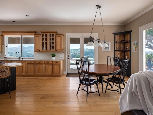 dining area featuring ornamental molding and light wood-style floors