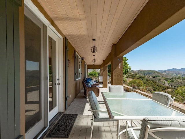 wooden deck with a mountain view and outdoor dining area