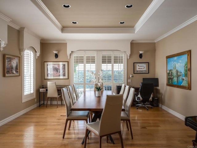 dining room with ornamental molding, plenty of natural light, and a raised ceiling