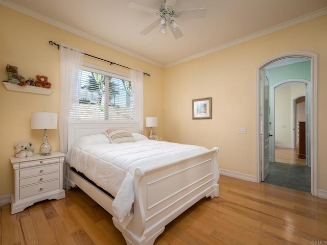 bedroom featuring light wood-style floors, arched walkways, and ornamental molding