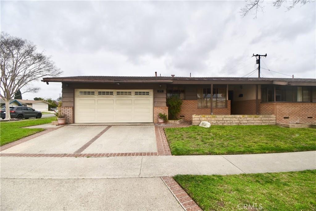 single story home with a front yard, brick siding, driveway, and an attached garage