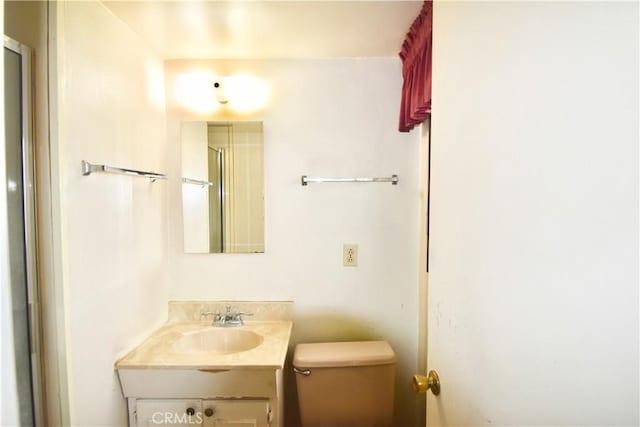 bathroom with vanity, toilet, and an enclosed shower