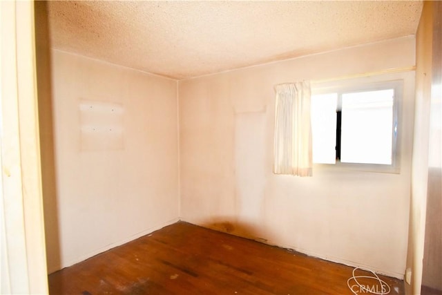 unfurnished room featuring a textured ceiling and wood finished floors