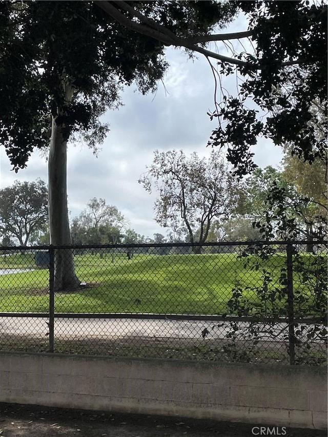 surrounding community with fence and a yard