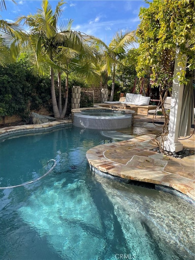 outdoor pool featuring an in ground hot tub and a patio area