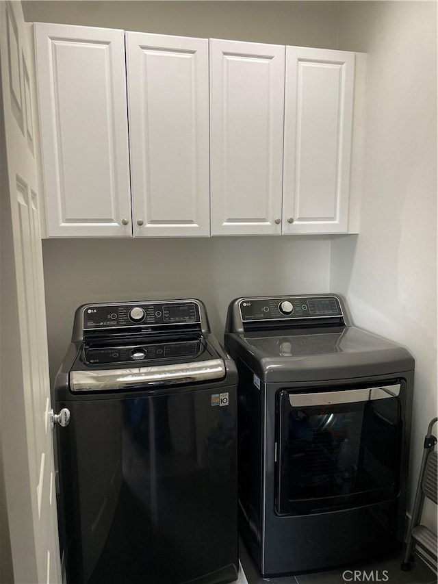 washroom with cabinet space and independent washer and dryer