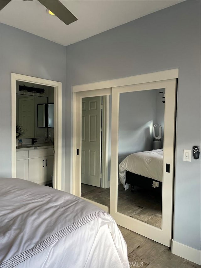 bedroom with a closet, ensuite bath, and wood finished floors